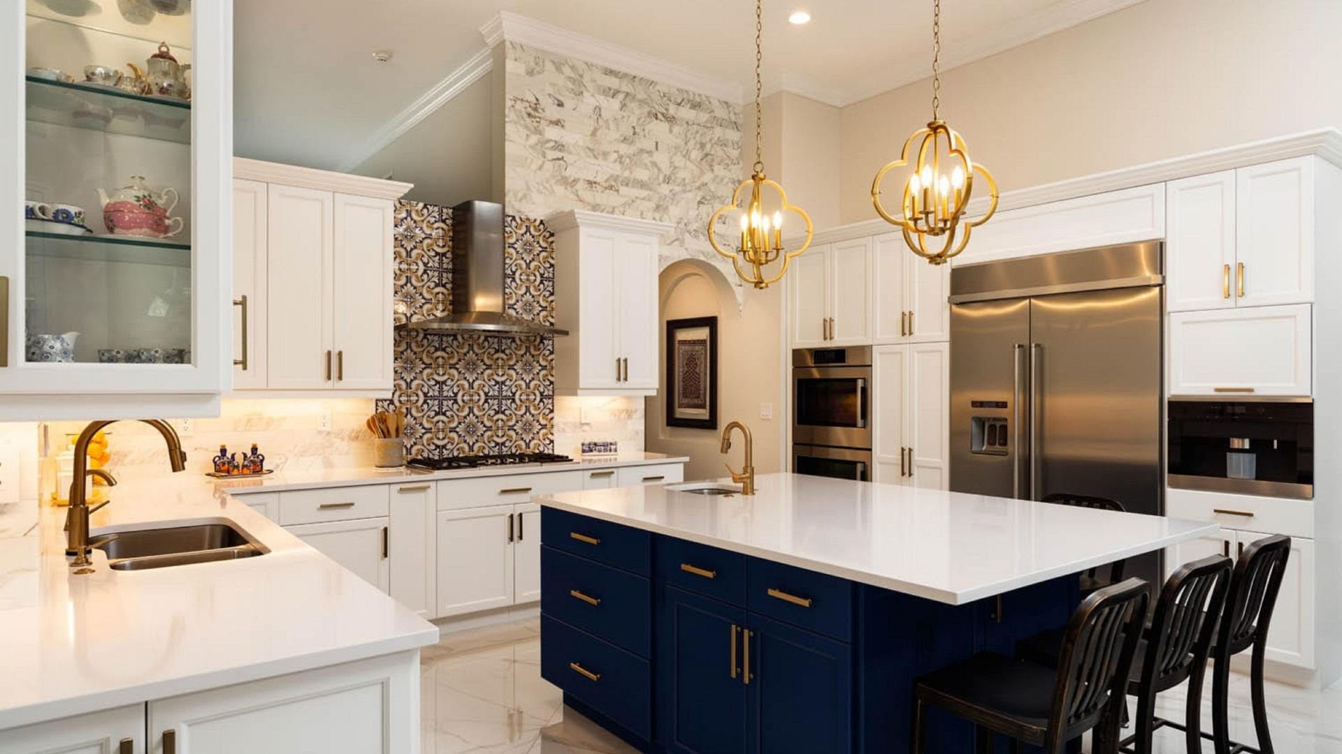 Elegant kitchen with white cabinets, blue island, and gold pendant lights