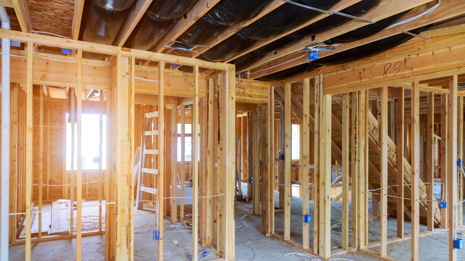 Wooden house framing with exposed studs and electrical wiring during construction
