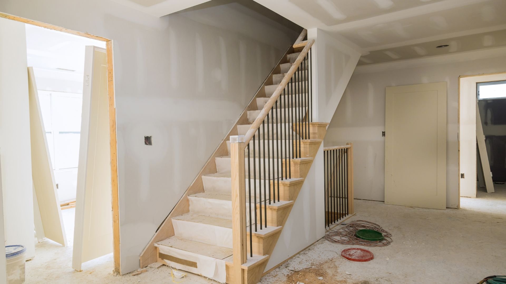 Interior home construction with wooden staircase and unfinished walls