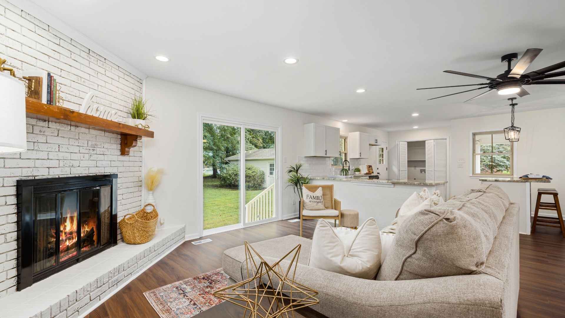 Cozy open-concept living room with fireplace, sliding door, and modern decor